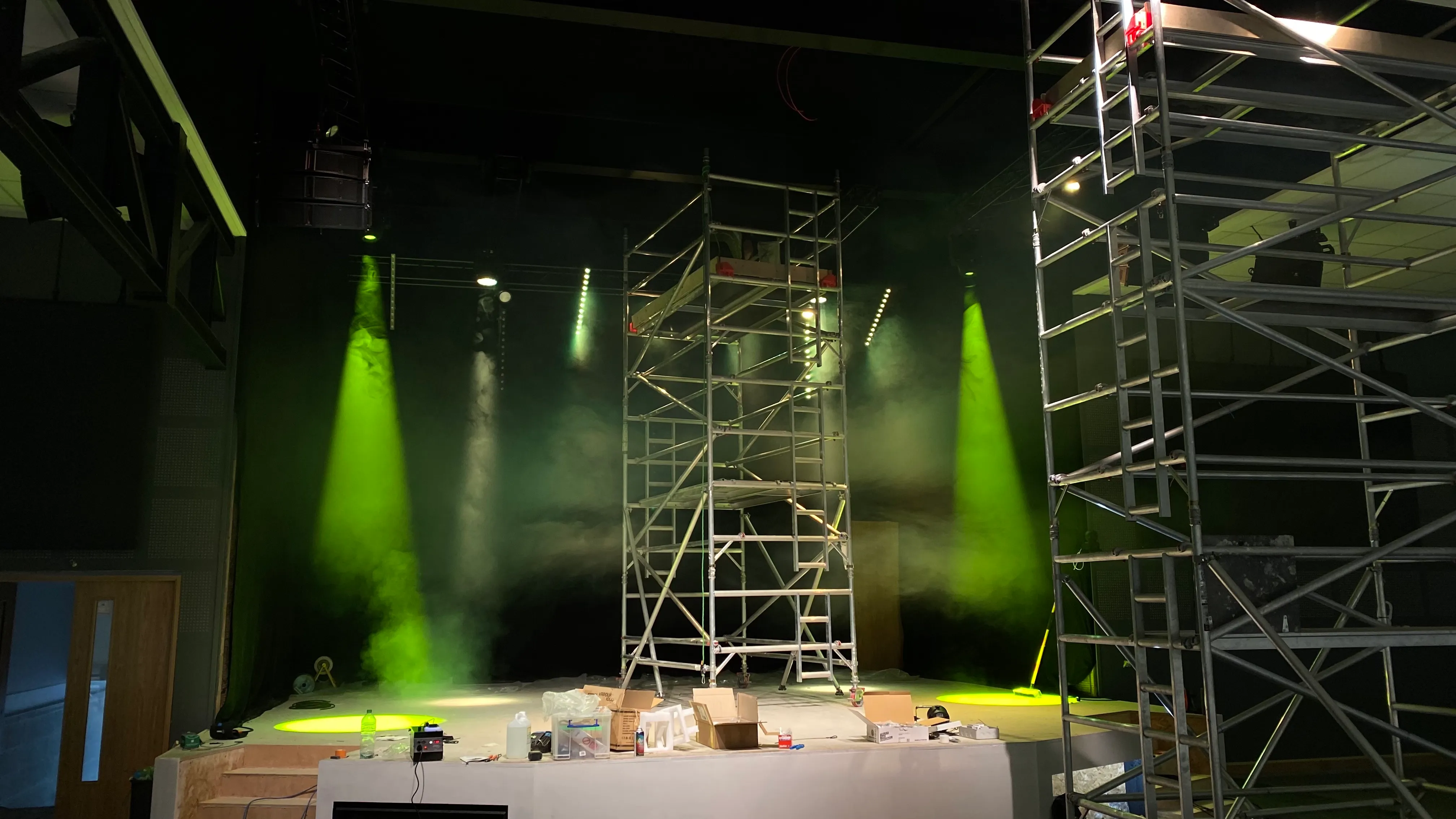 Moving-head lights beaming green over scaffolding during the install at Hope Church Ipswich